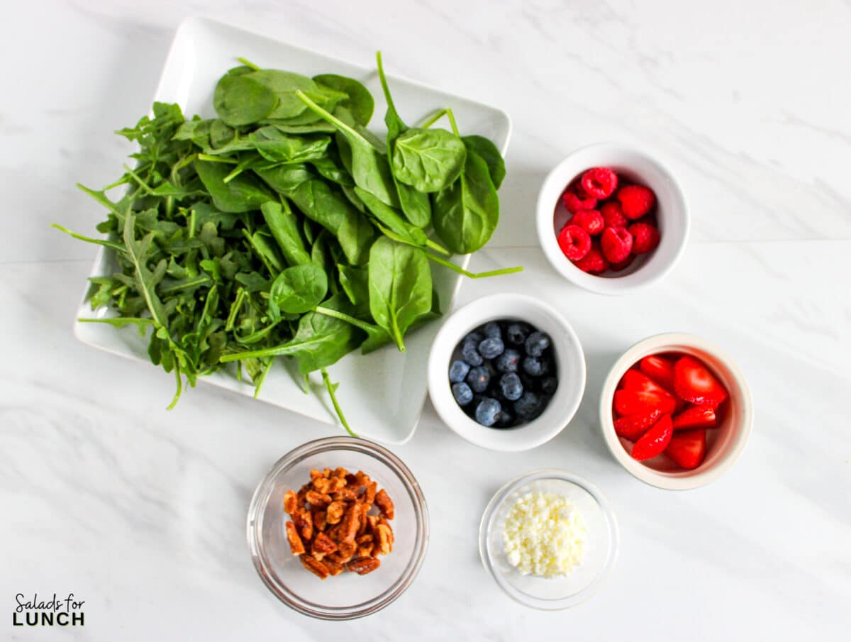 Berry Salad Recipe 1 - This Berry Salad with Creamy Balsamic Vinaigrette is a delightful mix of fresh baby spinach and arugula, sweet raspberries, blueberries, and strawberries, creamy goat cheese, and crunchy honey-roasted pecans. All of this is tossed together and drizzled with a homemade creamy balsamic vinaigrette. This salad is a beautiful balance of sweet, tangy, creamy, and crunchy in every bite.